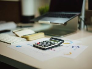 Calculator and paperwork on a desk, illustrating fund administration costs