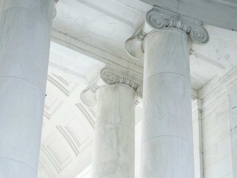 White marble columns on the facade of a classical stone building