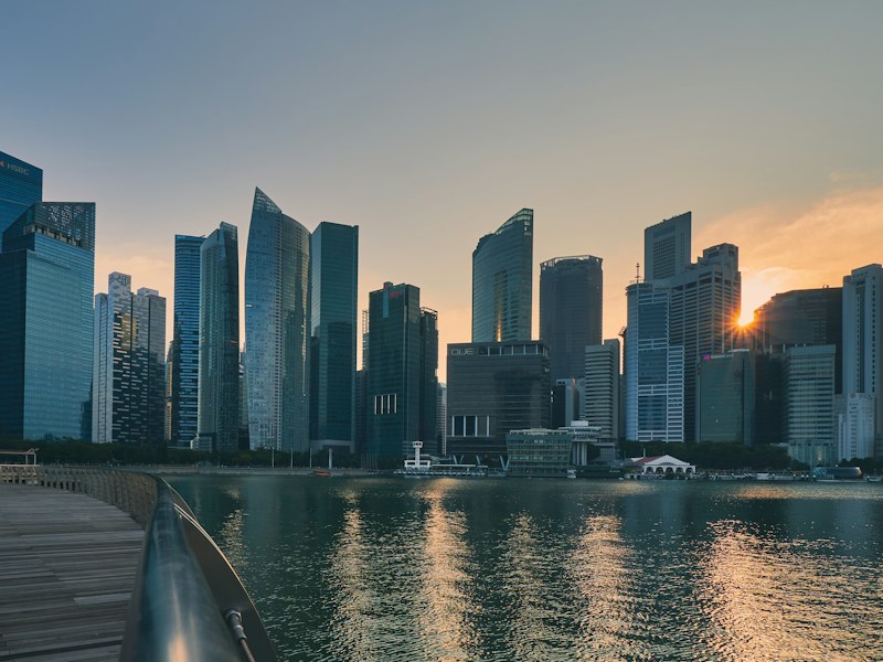 Singapore central business district skyline across Marina Bay at sunset