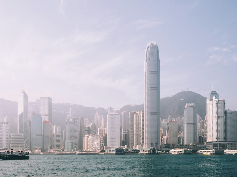 Hong Kong skyline above Victoria Harbour, with skyscrapers softened by light haze