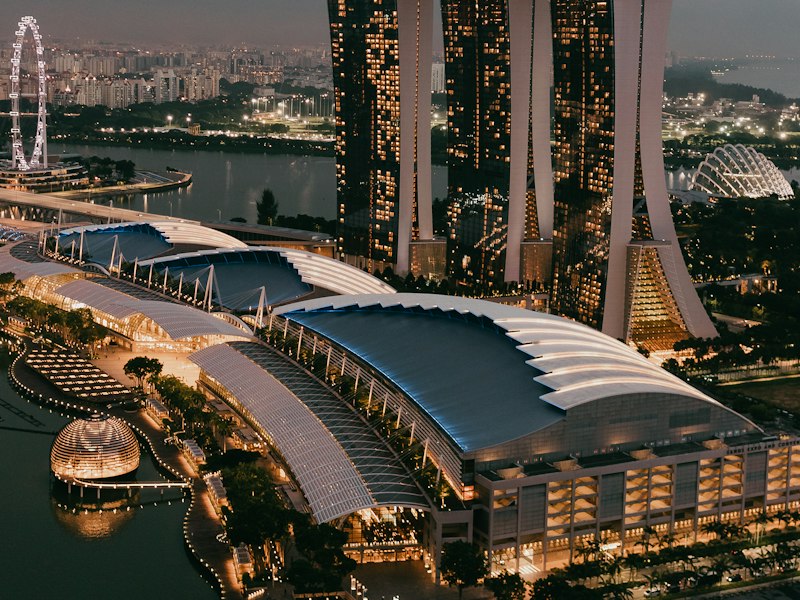 Aerial view of Marina Bay Sands and the Singapore Flyer at blue hour, with the city lit up at dusk