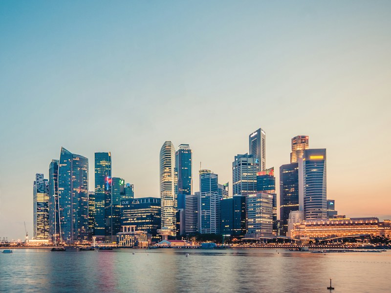Singapore central business district skyline across Marina Bay at dusk