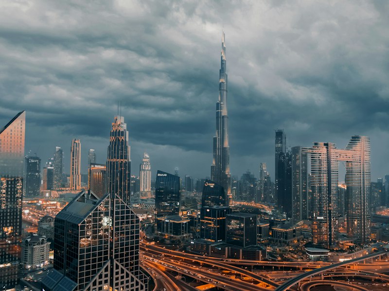 The Burj Khalifa rising above the skyline of Downtown Dubai under dark storm clouds